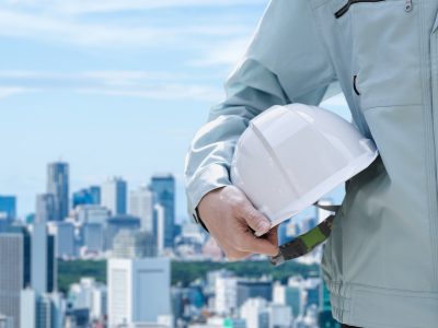 都市を背景にした建設作業員